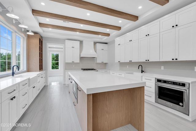 1423 Anthony Ct, Toms River, NJ 08753 - kitchen with stainless steel oven, custom range hood, a center island, light countertops, and white cabinets