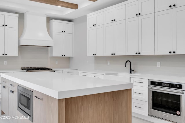 1423 Anthony Ct, Toms River, NJ 08753 - kitchen featuring custom exhaust hood, appliances with stainless steel finishes, light countertops, a center island, and white cabinetry