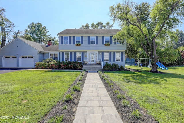 12 Harbor Ct, West Long Branch, NJ 07764 - colonial house featuring a playground, an attached garage, asphalt driveway, and a front yard