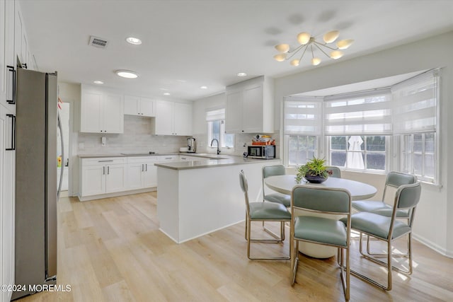 12 Harbor Ct, West Long Branch, NJ 07764 - kitchen featuring stainless steel appliances, light wood finished floors, white cabinets, decorative backsplash, and light countertops