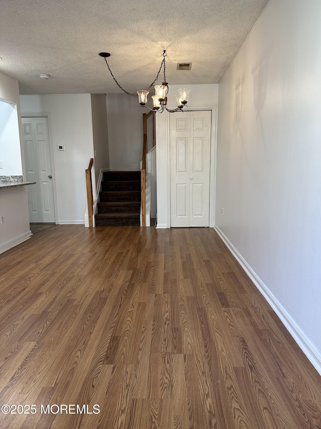 115 Brandywine Ct Unit 115, Brick, NJ 08724 - unfurnished dining area featuring stairway, a textured ceiling, dark wood-style floors, and a chandelier