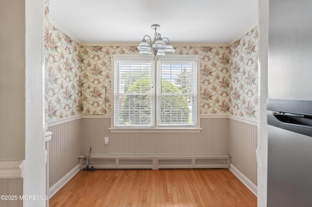 149 9th St, Belford, NJ 07718 - unfurnished dining area featuring wood finished floors, plenty of natural light, a chandelier, wainscoting, and wallpapered walls
