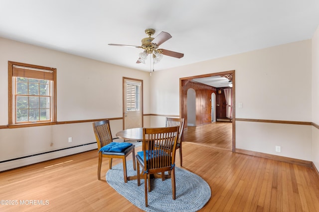 149 9th St, Belford, NJ 07718 - dining area featuring arched walkways, light wood-style floors, ceiling fan, and baseboard heating