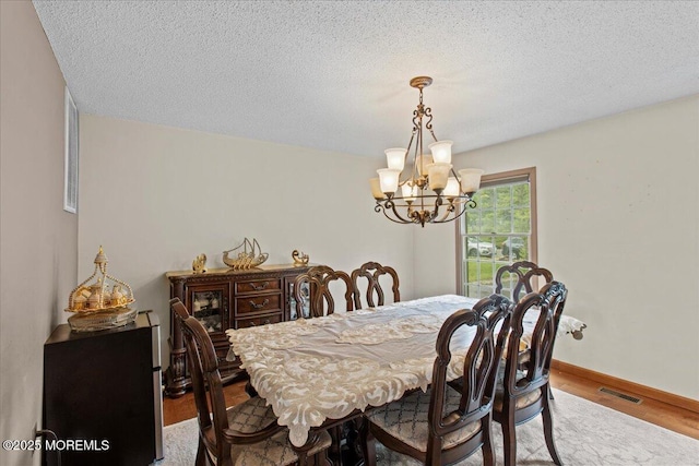 519 Gilford Ave, Toms River, NJ 08753 - dining area with a chandelier, wood finished floors, and a textured ceiling