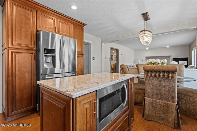 519 Gilford Ave, Toms River, NJ 08753 - kitchen with appliances with stainless steel finishes, open floor plan, wood-type flooring, light stone countertops, and a textured ceiling