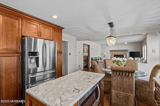 519 Gilford Ave, Toms River, NJ 08753 - kitchen with appliances with stainless steel finishes, wood finished floors, a textured ceiling, brown cabinetry, and open floor plan
