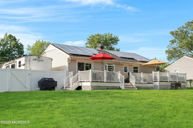 5 Robert Ave, Howell, NJ 07731 - rear view of property featuring a gate, roof mounted solar panels, a wooden deck, and a chimney