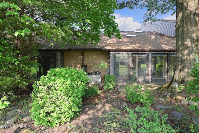 33 Claremont Ct, Red Bank, NJ 07701 - rear view of house with roof with shingles, brick siding, and a sunroom