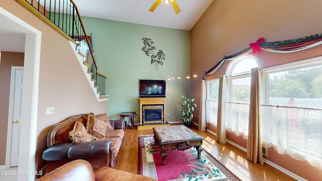 5 Samantha Dr, Monroe, NJ 08831 - living area with wood finished floors, a ceiling fan, stairway, a glass covered fireplace, and a high ceiling