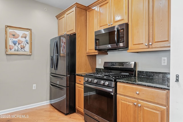 632 Sophee Ln, Lakewood, NJ 08701 - kitchen featuring fridge with ice dispenser, gas range, dark stone counters, and light wood-style floors