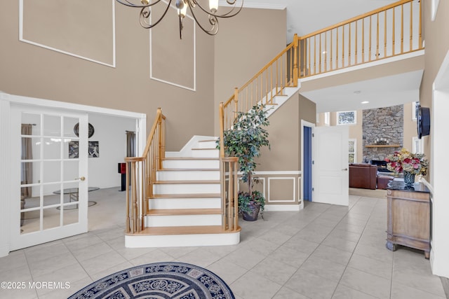 329 Valley View Cir, Freehold, NJ 07728 - stairway featuring a towering ceiling, a chandelier, a stone fireplace, and tile patterned flooring