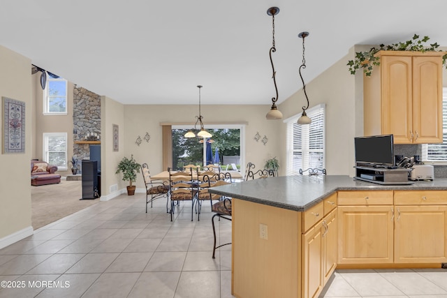 329 Valley View Cir, Freehold, NJ 07728 - kitchen with light brown cabinetry, dark countertops, a fireplace, a breakfast bar area, and light tile patterned floors