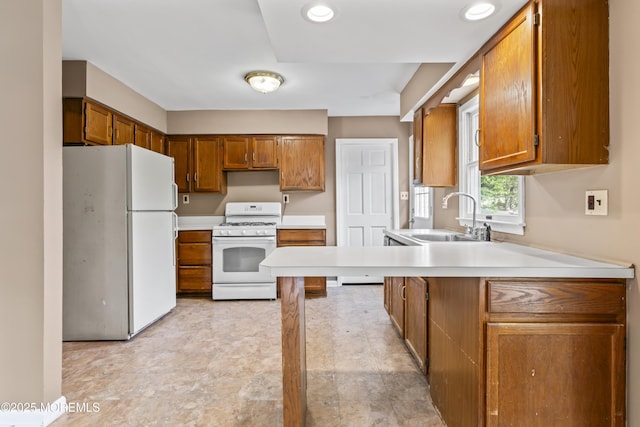 76 9th St, Belford, NJ 07718 - kitchen featuring white appliances, brown cabinets, light countertops, and a peninsula