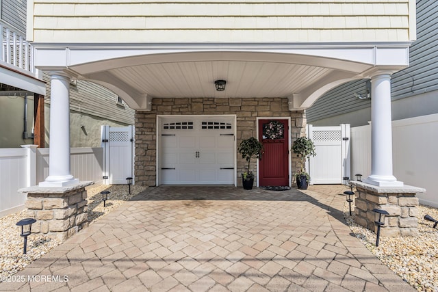 14 Seadrift Ave, Highlands, NJ 07732 - view of exterior entry with a gate, stone siding, decorative driveway, and an attached garage
