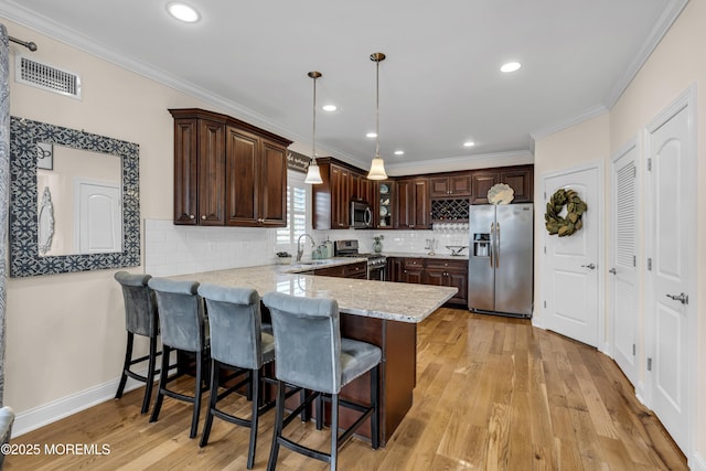 14 Seadrift Ave, Highlands, NJ 07732 - kitchen with stainless steel appliances, a peninsula, dark brown cabinets, a kitchen bar, and crown molding