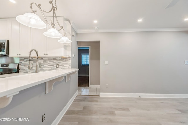 6 S Heron St Unit A, Manchester, NJ 08759 - kitchen with stainless steel appliances, tasteful backsplash, white cabinets, crown molding, and light wood finished floors
