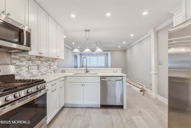6 S Heron St Unit A, Manchester, NJ 08759 - kitchen with appliances with stainless steel finishes, crown molding, a peninsula, white cabinets, and decorative backsplash