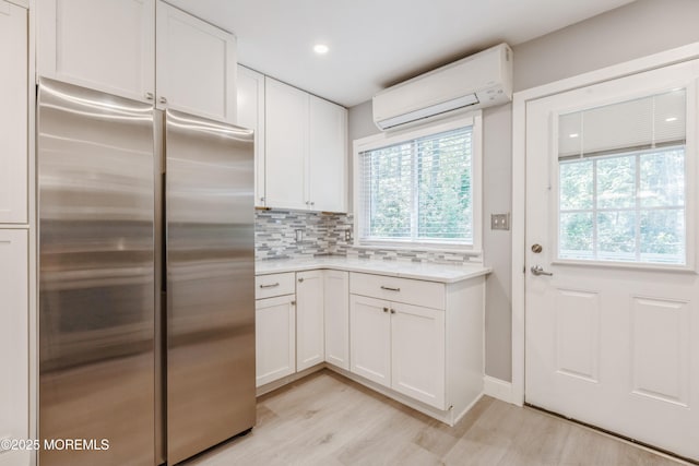 6 S Heron St Unit A, Manchester, NJ 08759 - kitchen featuring stainless steel refrigerator, a wall unit AC, light wood finished floors, light countertops, and plenty of natural light