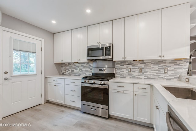 6 S Heron St Unit A, Manchester, NJ 08759 - kitchen featuring stainless steel appliances, white cabinetry, light wood-style floors, backsplash, and recessed lighting