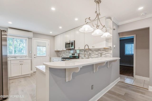 6 S Heron St Unit A, Manchester, NJ 08759 - kitchen featuring stainless steel appliances, a wall unit AC, a baseboard radiator, backsplash, and ornamental molding