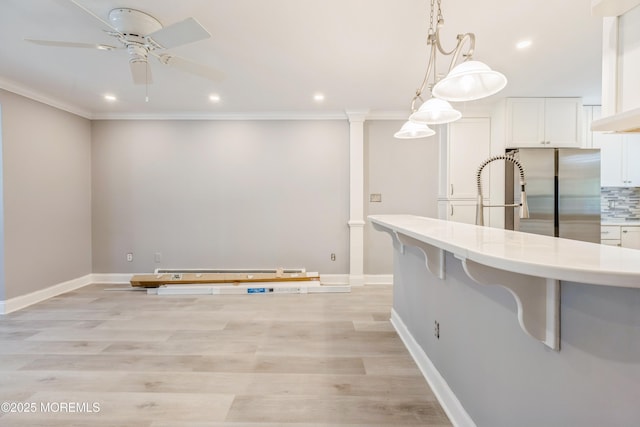 6 S Heron St Unit A, Manchester, NJ 08759 - kitchen with freestanding refrigerator, a ceiling fan, a baseboard heating unit, white cabinetry, and ornamental molding