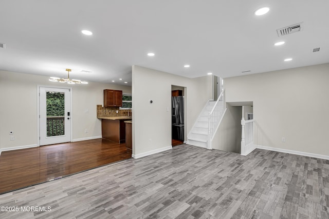 1217 Madison Ave, Toms River, NJ 08757 - unfurnished living room with wood finished floors, recessed lighting, a chandelier, and stairs