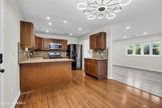 1217 Madison Ave, Toms River, NJ 08757 - kitchen featuring stainless steel appliances, wood finished floors, decorative backsplash, recessed lighting, and a chandelier