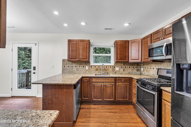 1217 Madison Ave, Toms River, NJ 08757 - kitchen featuring appliances with stainless steel finishes, a peninsula, light wood finished floors, plenty of natural light, and recessed lighting