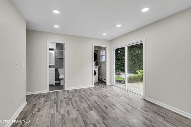 1217 Madison Ave, Toms River, NJ 08757 - unfurnished bedroom featuring stacked washer / drying machine, wood finished floors, baseboard heating, access to outside, and connected bathroom