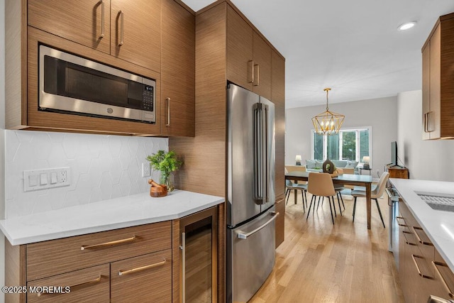 8 Eunice Ter, West Long Branch, NJ 07764 - kitchen featuring stainless steel appliances, beverage cooler, brown cabinets, tasteful backsplash, and recessed lighting
