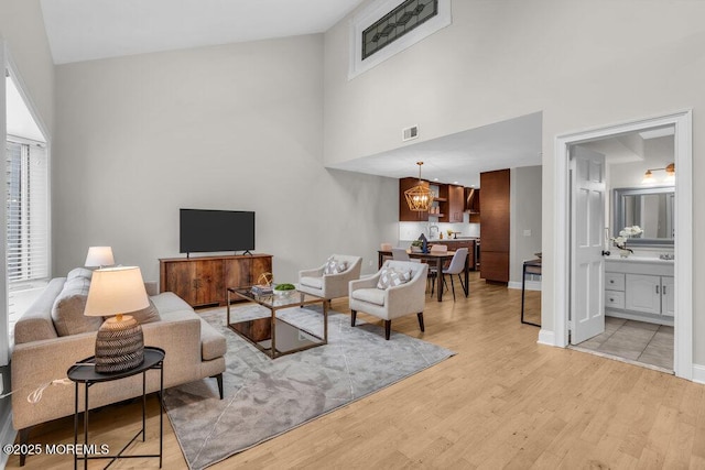 8 Eunice Ter, West Long Branch, NJ 07764 - living area with a towering ceiling, light wood finished floors, and a chandelier