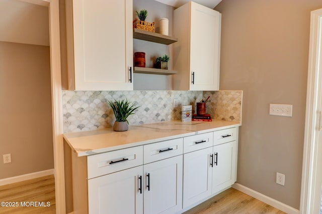 42 Cherry Tree Farm Rd, Middletown, NJ 07748 - kitchen featuring open shelves, light wood-style floors, decorative backsplash, white cabinetry, and light stone countertops