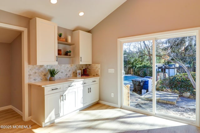 42 Cherry Tree Farm Rd, Middletown, NJ 07748 - kitchen with open shelves, tasteful backsplash, light wood finished floors, light countertops, and vaulted ceiling
