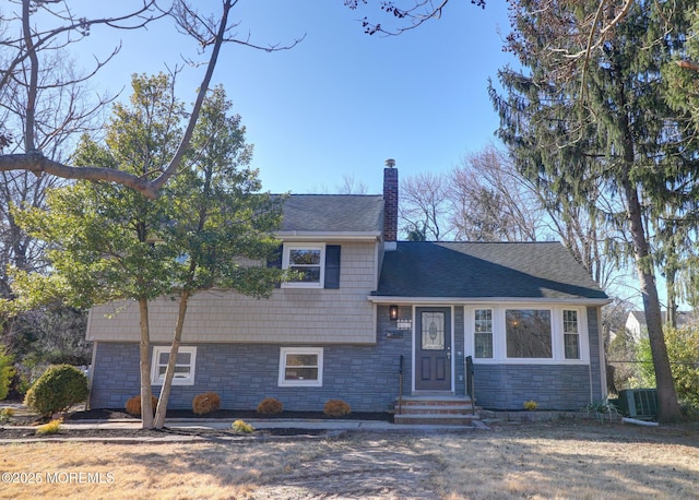 42 Cherry Tree Farm Rd, Middletown, NJ 07748 - tri-level home with stone siding, a chimney, entry steps, and roof with shingles