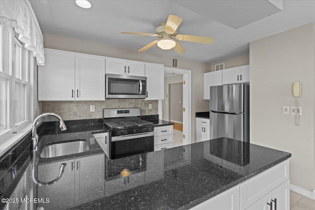 50 Normanton Ave, Manchester, NJ 08759 - kitchen featuring appliances with stainless steel finishes, white cabinets, a ceiling fan, tasteful backsplash, and dark stone counters