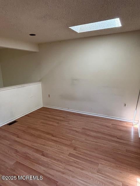 133 Sunnymede St, Englishtown, NJ 07726 - spare room featuring wood finished floors, a textured ceiling, and a skylight