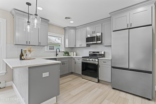 696 Jamaica Blvd, Toms River, NJ 08757 - kitchen with stainless steel appliances, gray cabinetry, a peninsula, tasteful backsplash, and light wood-style floors