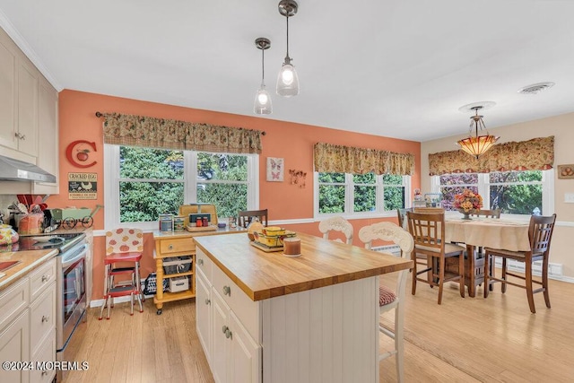 8 Wisconsin Ln, Whiting, NJ 08759 - kitchen with stainless steel range with electric stovetop, light wood-style floors, butcher block countertops, decorative light fixtures, and a breakfast bar area