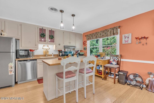8 Wisconsin Ln, Whiting, NJ 08759 - kitchen with appliances with stainless steel finishes, backsplash, light wood-type flooring, under cabinet range hood, and hanging light fixtures