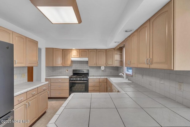 1316 Sunset Ave, Point Pleasant, NJ 08742 - kitchen featuring black gas range, tile countertops, freestanding refrigerator, under cabinet range hood, and decorative backsplash