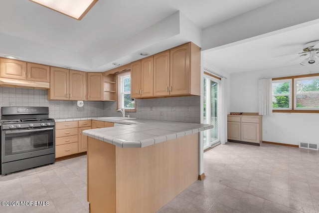 1316 Sunset Ave, Point Pleasant, NJ 08742 - kitchen with range with gas cooktop, under cabinet range hood, tile countertops, and plenty of natural light