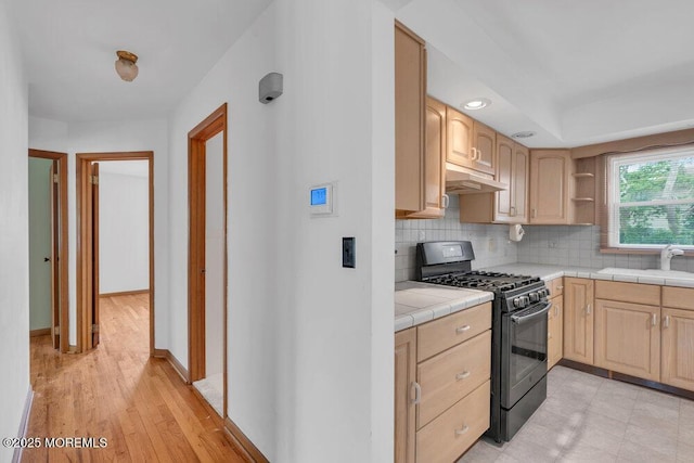 1316 Sunset Ave, Point Pleasant, NJ 08742 - kitchen featuring black gas stove, tile counters, light brown cabinetry, under cabinet range hood, and tasteful backsplash