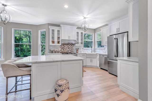 8 Armistead Ky, Colts Neck, NJ 07722 - kitchen with stainless steel appliances, a chandelier, under cabinet range hood, tasteful backsplash, and white cabinetry