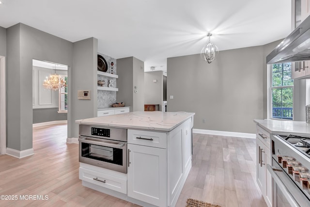 8 Armistead Ky, Colts Neck, NJ 07722 - kitchen with a chandelier, wall chimney range hood, open shelves, high end stainless steel range, and light wood finished floors