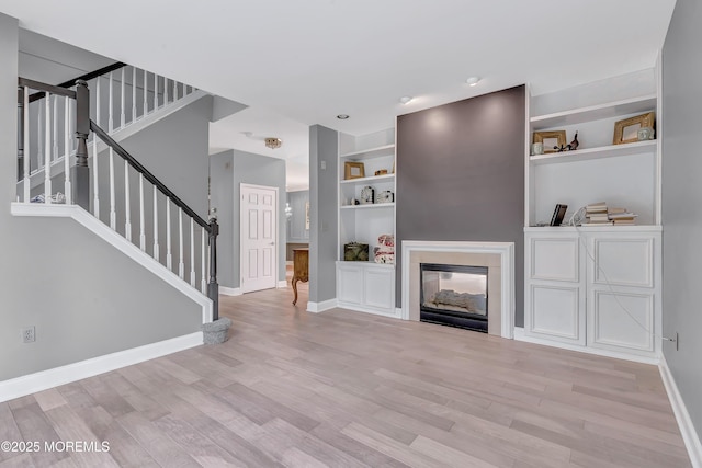 8 Armistead Ky, Colts Neck, NJ 07722 - unfurnished living room featuring stairs, wood finished floors, built in features, and a multi sided fireplace