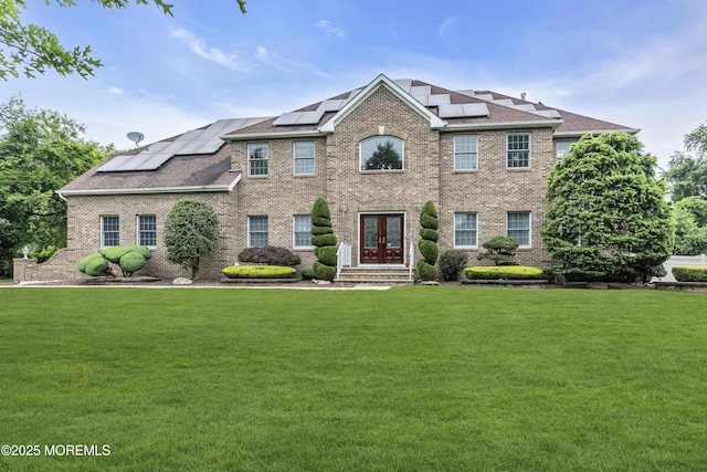 2 Michaels Ct, Jackson, NJ 08527 - view of front of home with french doors, a front yard, brick siding, and roof mounted solar panels