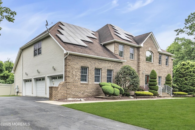 2 Michaels Ct, Jackson, NJ 08527 - view of front of home featuring a garage, brick siding, asphalt driveway, roof mounted solar panels, and a shingled roof
