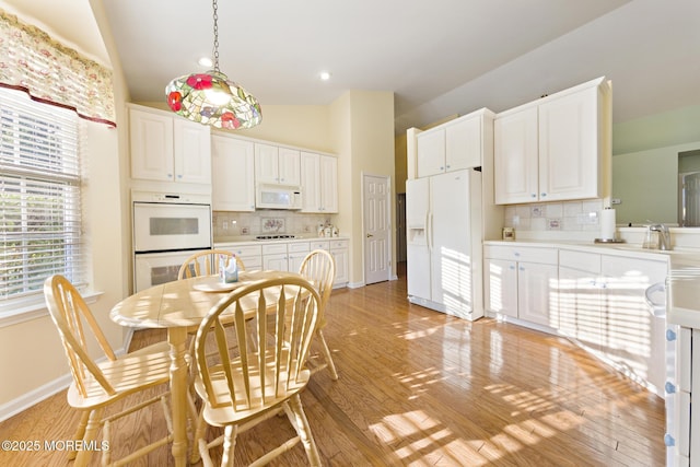 105 Golf View Dr, Little Egg Harbor, NJ 08087 - kitchen with white appliances, backsplash, light wood-type flooring, vaulted ceiling, and white cabinets
