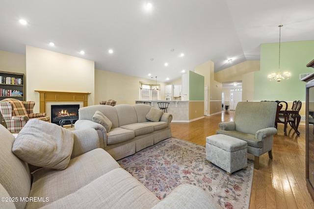 105 Golf View Dr, Little Egg Harbor, NJ 08087 - living room featuring wood finished floors, a glass covered fireplace, a chandelier, lofted ceiling, and recessed lighting