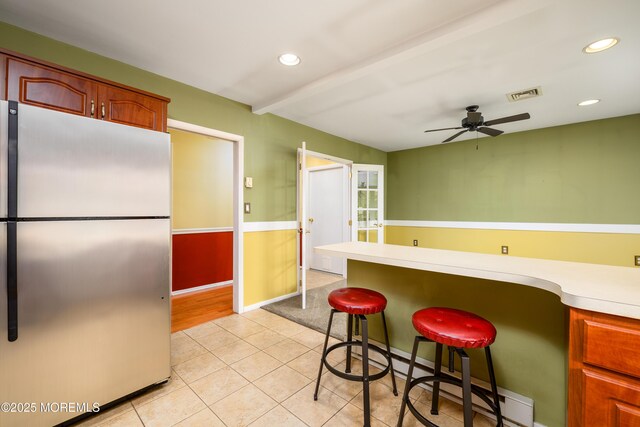 1161B Argyll Cir, Lakewood, NJ 08701 - kitchen featuring freestanding refrigerator, light countertops, ceiling fan, light tile patterned floors, and a kitchen bar